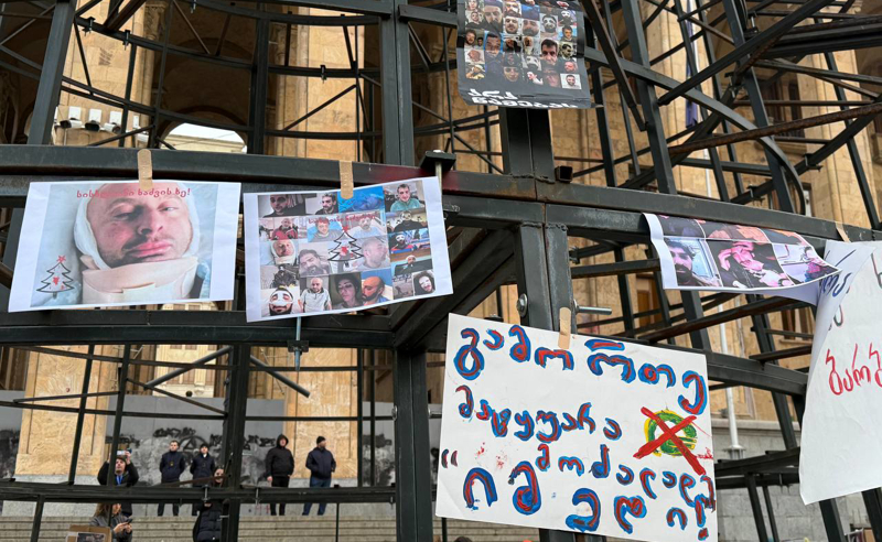 ჟურნალისტებმა პარლამენტთან, ნაძვის ხის კონსტრუქციაზე ნაცემი ჟურნალისტების ფოტოები ჩამოკიდეს